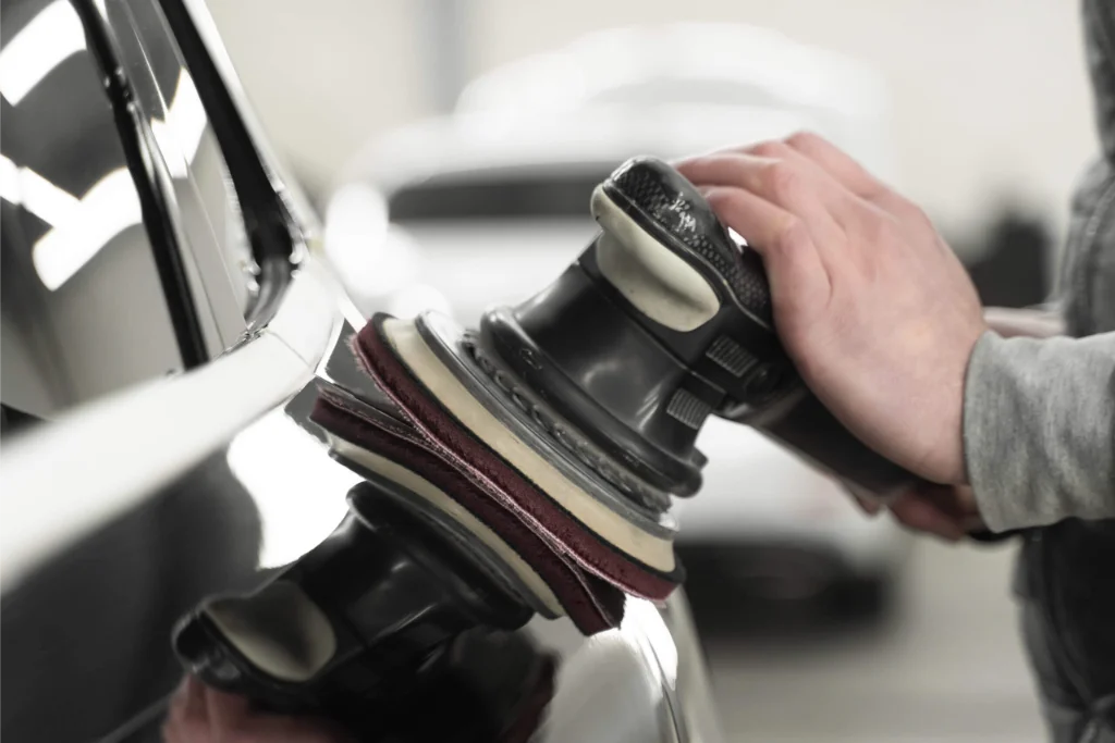 Hand eines Mechanikers beim Polieren eines Autos bei Kayki-Autoservice in Hildesheim.